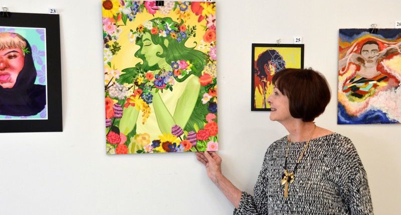 Woman admiring student artwork at the Congressional Art Competition gallery